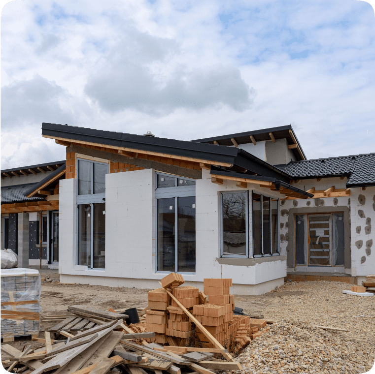 Modern house under construction with cloudy sky.